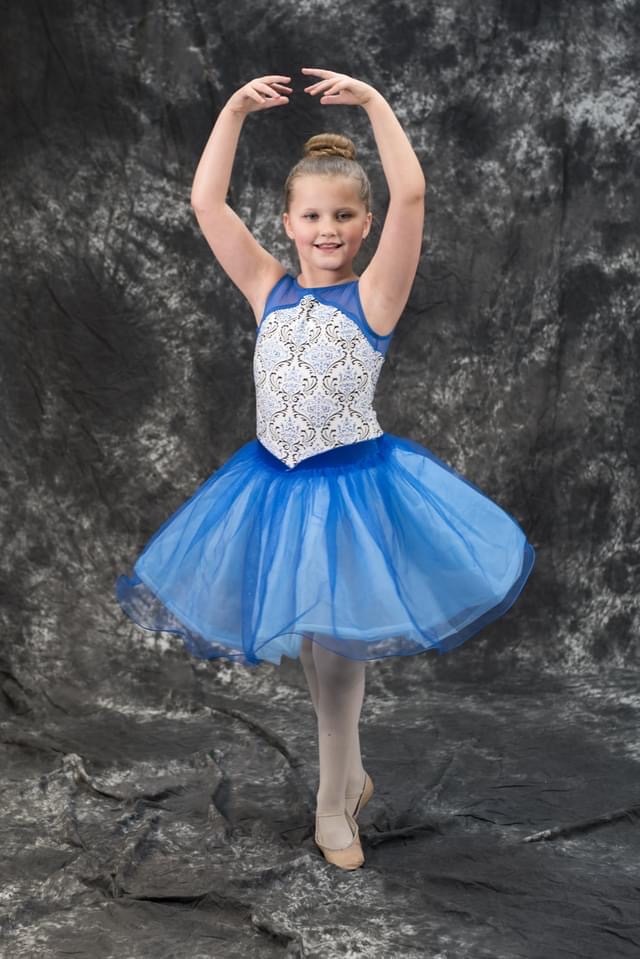 Oxbow Dance ballet student in a blue tutu posing in fifth position