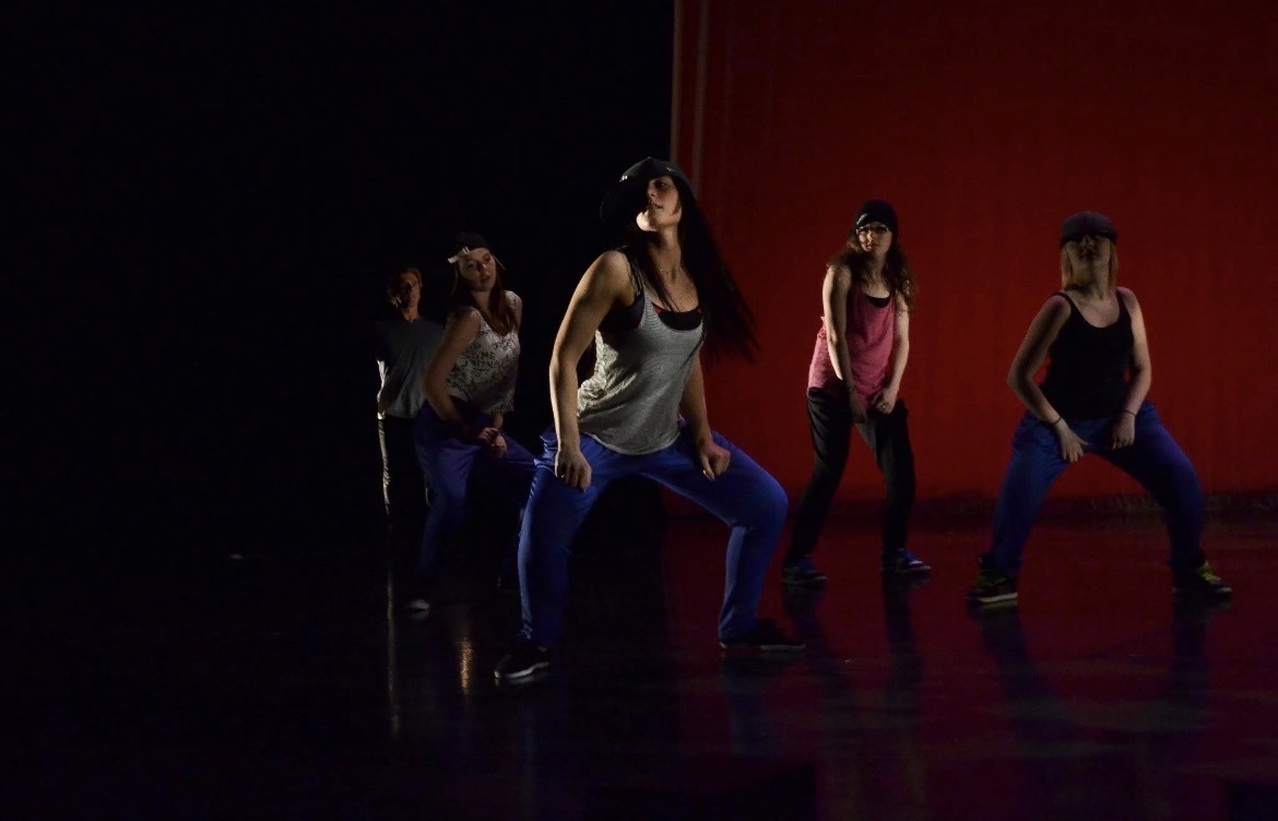 Oxbow Dance hip hop dancers performing on stage in caps